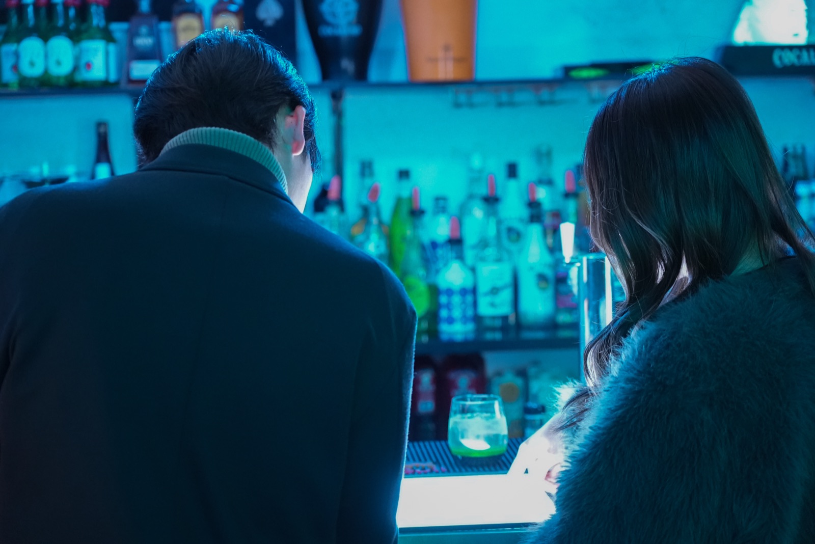 バーカウンターで並んで過ごす男女